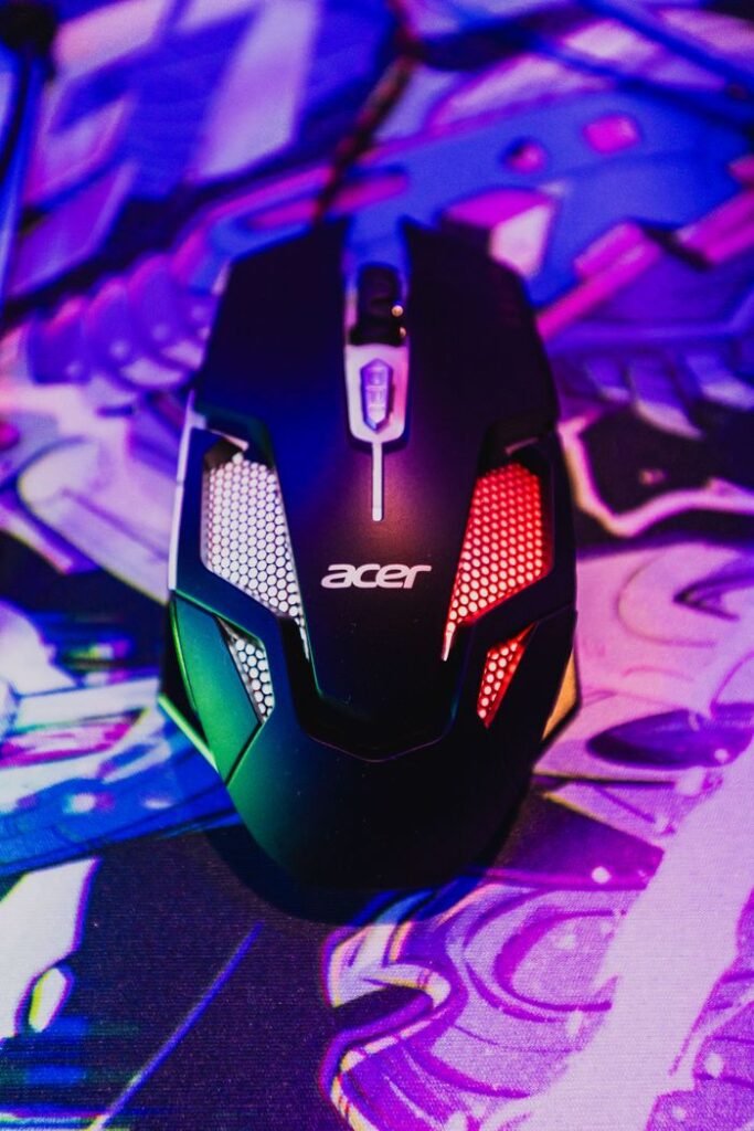 Close-up of a gaming mouse illuminated by RGB lighting on a colorful abstract pad, perfect for tech enthusiasts.