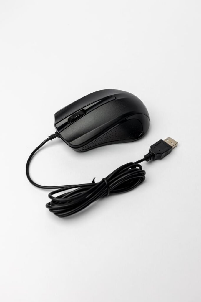 Close-up of a black USB wired computer mouse on a white background, ideal for tech-related content.