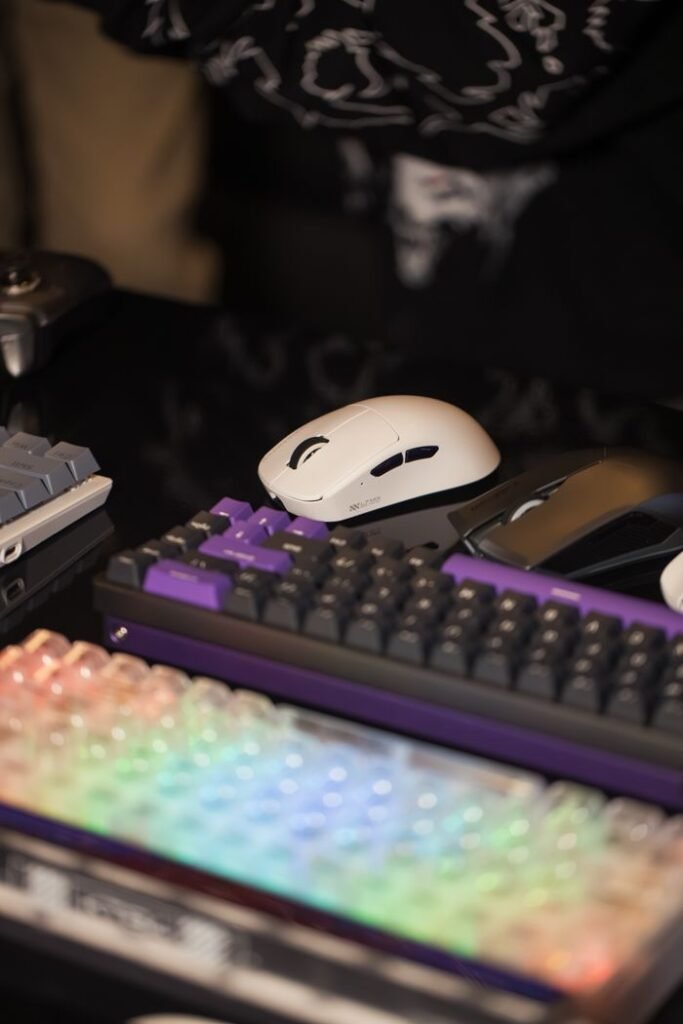 Vibrant gaming setup featuring colorful mechanical keyboards and sleek white mouse.